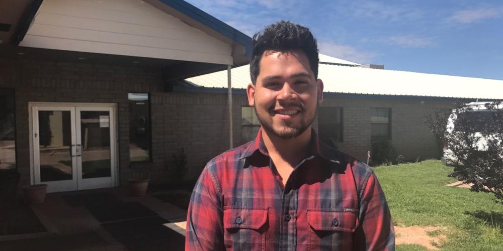 Boys’ dean Pierre Ortiz, 24, standing outside his dormitory at Holbrook Indian School in Holbrook, Arizona. (Andrew McChesney / Adventist Mission)