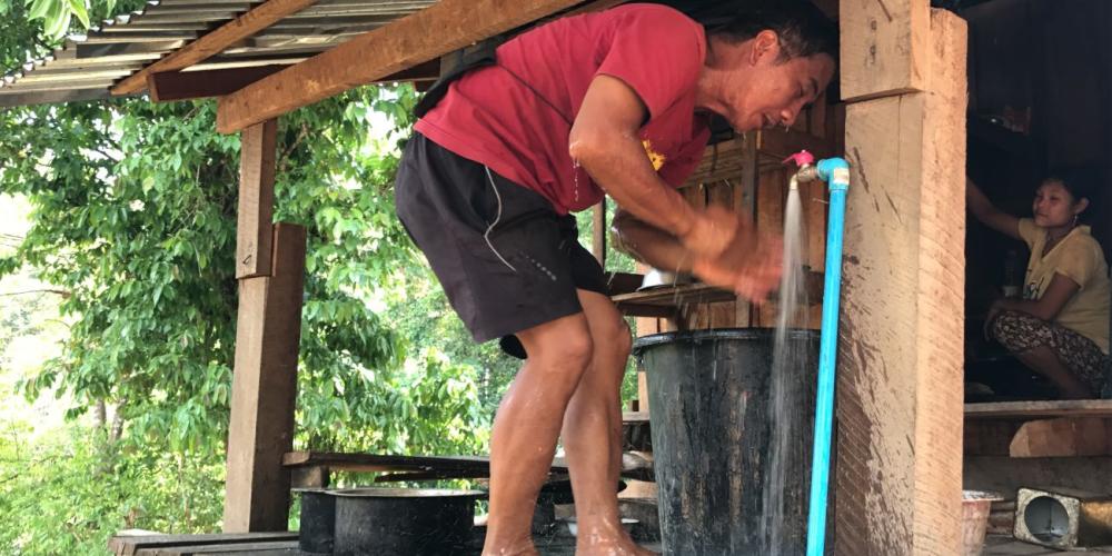 A villager rinsing with water from the new faucet attached to the student missionary-provided water pipeline in Myanmar. (All photos: Tranqui Vergara)