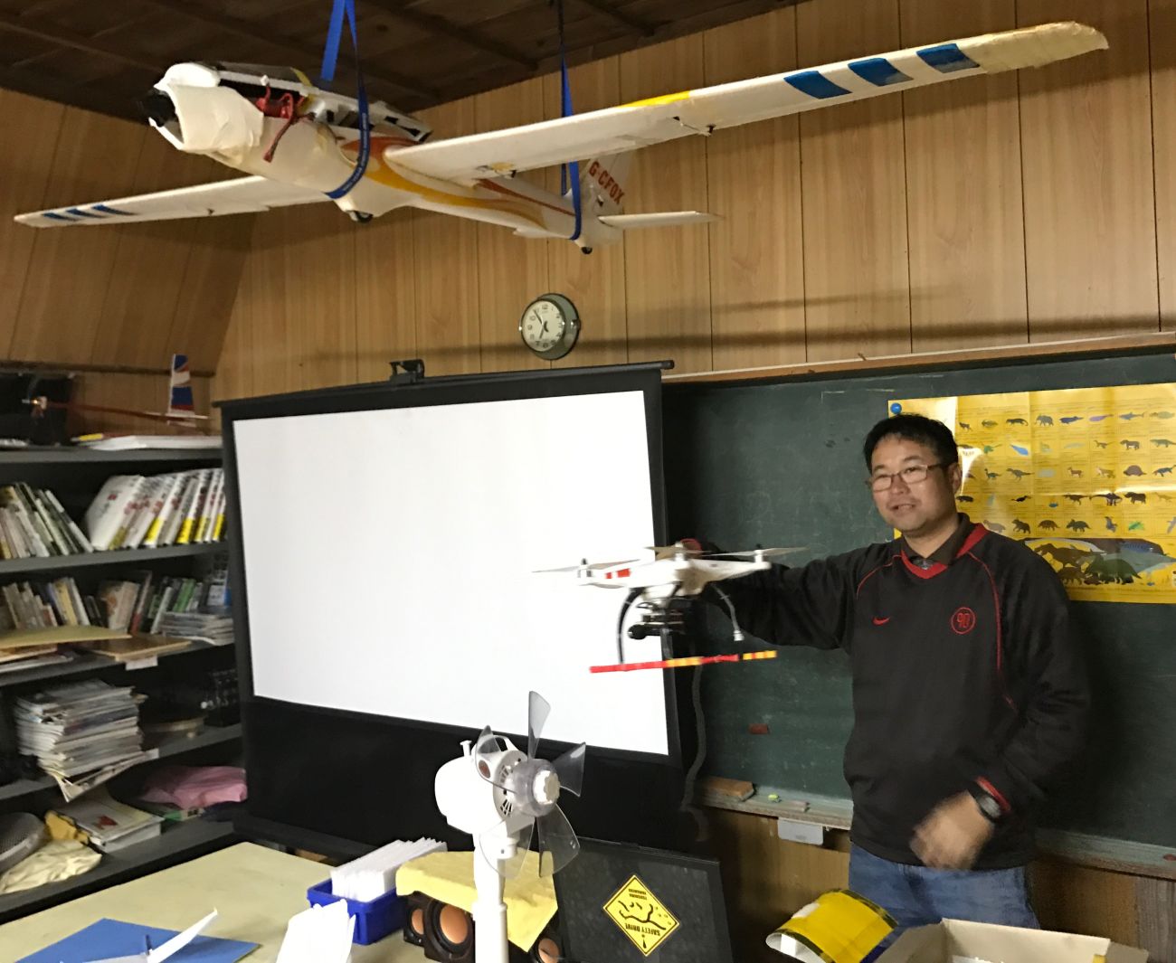 Kurihara Kimiyoshi playing with one of the many aircraft in his classroom. (Andrew McChesney / Adventist Mission)